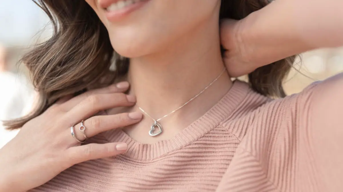 Close-up shot of a beautiful young woman wearing beautiful silver necklace and rings
