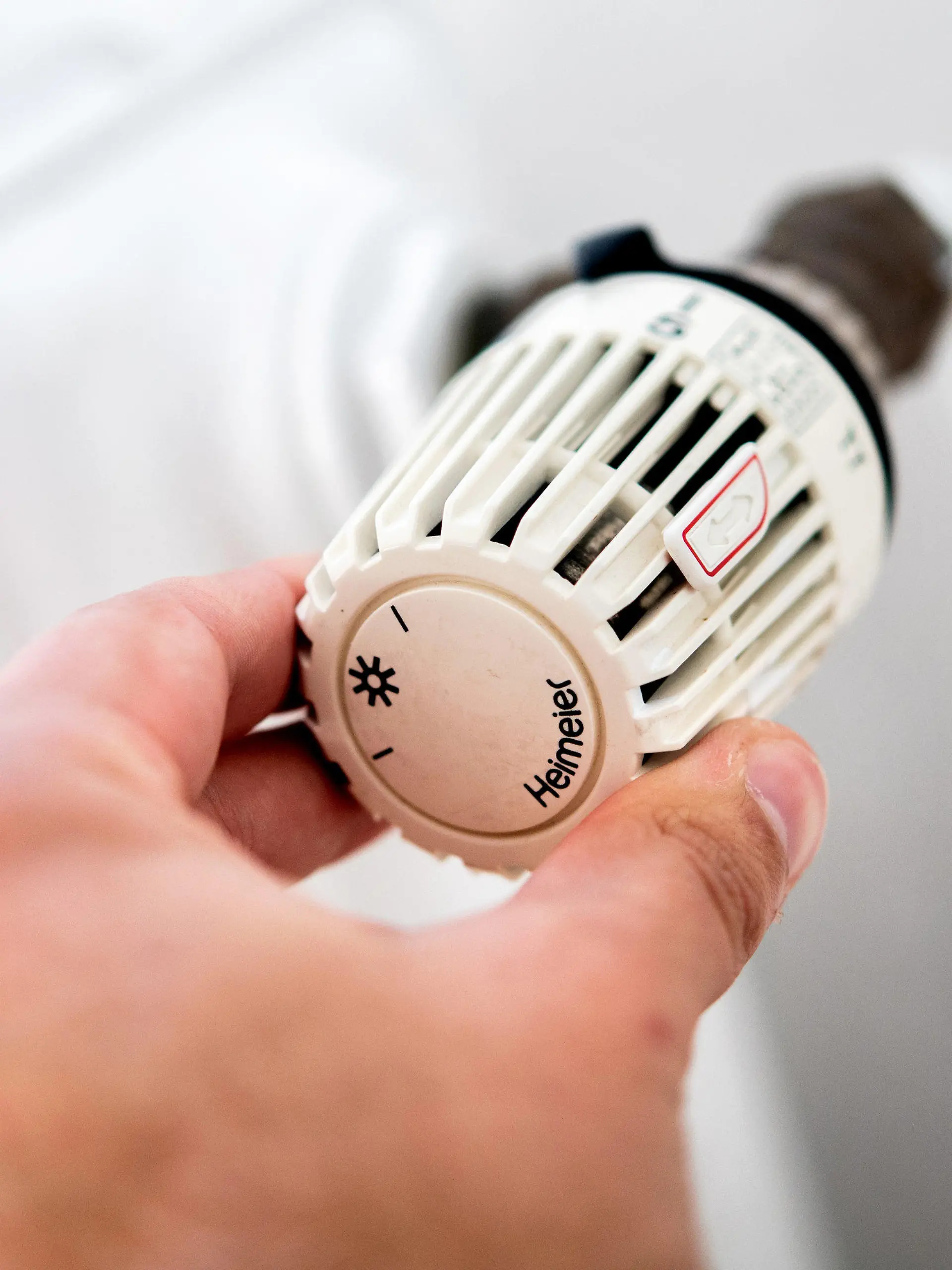 ARCHIV - 04.10.2021, Niedersachsen, Hannover: Ein Mann dreht in einer Wohnung am Thermostat einer Heizung. (zu dpa: "Bundesregierung bringt Soforthilfe für Gaskunden auf den Weg") Foto: Hauke-Christian Dittrich/dpa +++ dpa-Bildfunk +++
