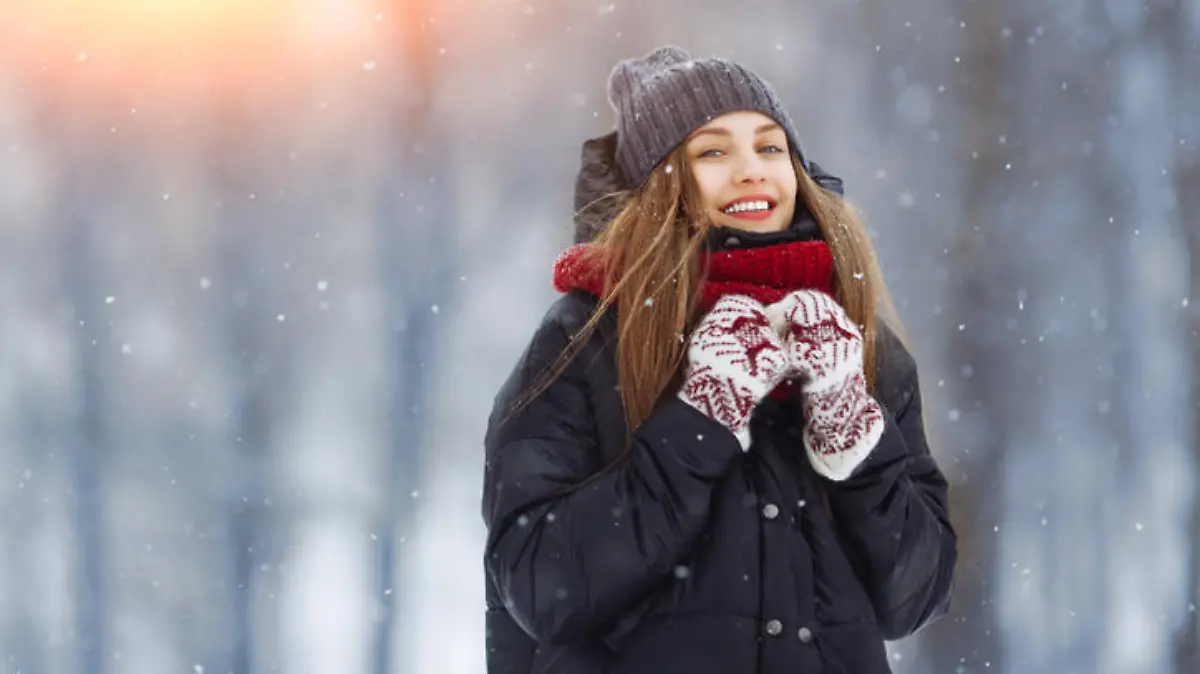 Winter young woman portrait. Beauty Joyful Model Girl laughing and having fun in winter park. Beautiful young woman laughing outdoors. Enjoying nature, wintertime.