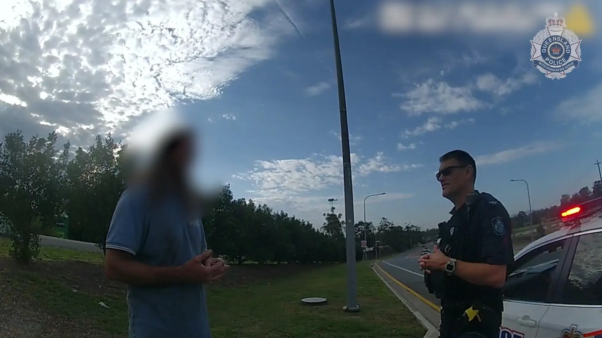 SCREENSHOT - 21.11.2023, Australien, Coomera: HANDOUT - Dieses Videostandbild von der Polizei Queensland zeigt einen 43-jährigen Mann, der mit der Polizei spricht. Um das Geld für ein Taxi zu sparen und 50 Kilometer gratis mitzufahren, hat sich ein betrunkener Australier auf dem Unterbau eines Lastwagens eingepfercht. Der Truck war ohne Zwischenstopp auf dem Weg in einen anderen Bundesstaat. Am Ende musste der Mann rund 400 Kilometer in prekärer Position auf dem Metallgestell ausharren - nur einen halben Meter über der Fahrbahn hängend. Foto: Queensland Police/QUEENSLAND POLICE/AP/dpa - ACHTUNG: Verwendung nur im vollen Format und vollständigen Credti +++ dpa-Bildfunk +++