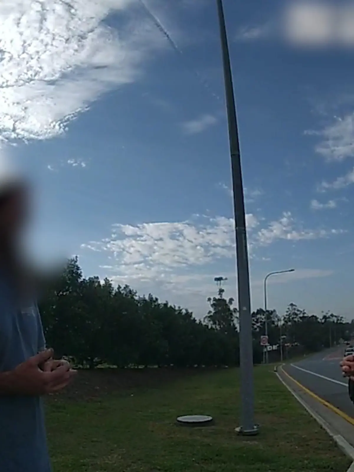 SCREENSHOT - 21.11.2023, Australien, Coomera: HANDOUT - Dieses Videostandbild von der Polizei Queensland zeigt einen 43-jährigen Mann, der mit der Polizei spricht. Um das Geld für ein Taxi zu sparen und 50 Kilometer gratis mitzufahren, hat sich ein betrunkener Australier auf dem Unterbau eines Lastwagens eingepfercht. Der Truck war ohne Zwischenstopp auf dem Weg in einen anderen Bundesstaat. Am Ende musste der Mann rund 400 Kilometer in prekärer Position auf dem Metallgestell ausharren - nur einen halben Meter über der Fahrbahn hängend. Foto: Queensland Police/QUEENSLAND POLICE/AP/dpa - ACHTUNG: Verwendung nur im vollen Format und vollständigen Credti +++ dpa-Bildfunk +++