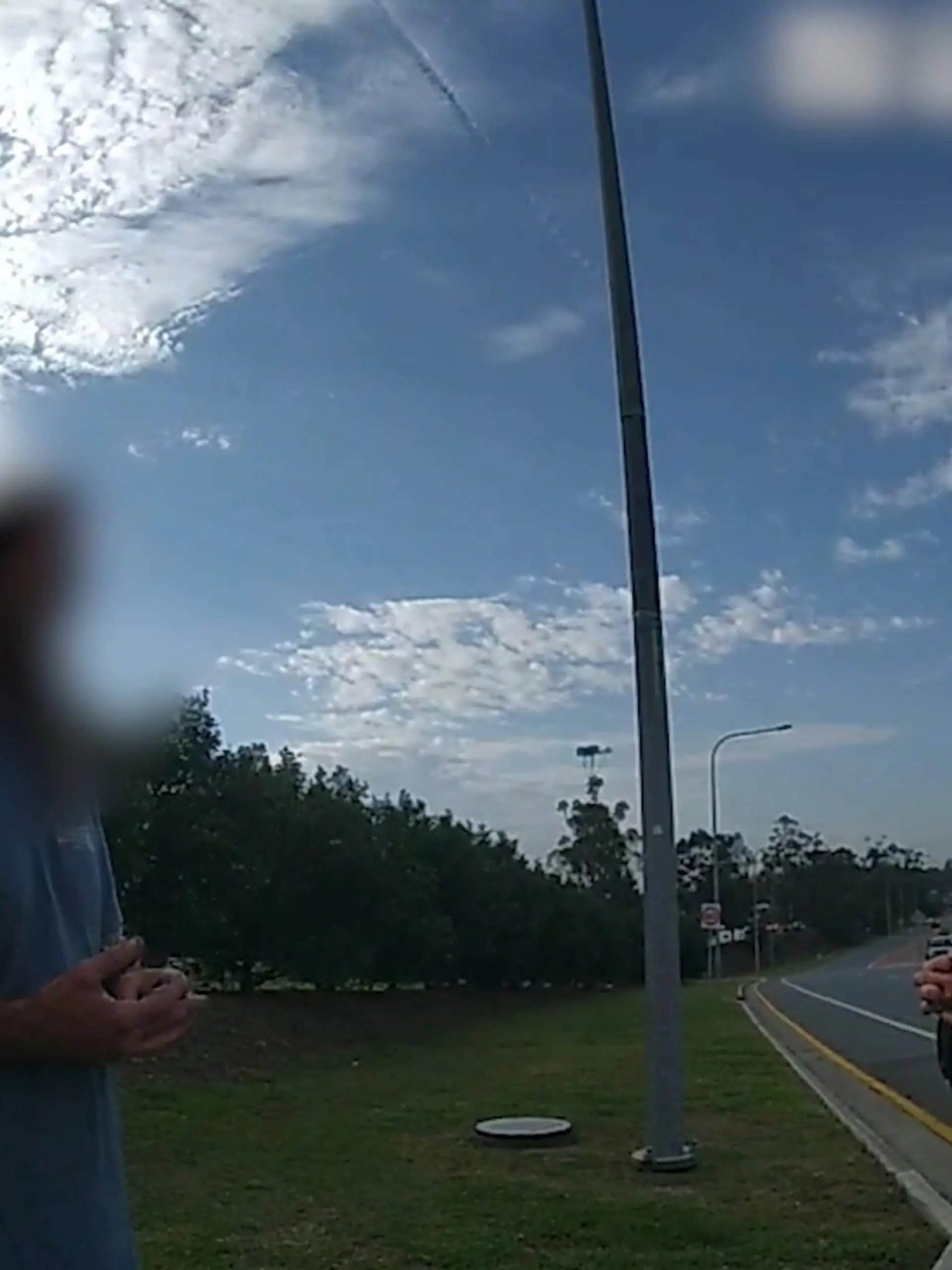 SCREENSHOT - 21.11.2023, Australien, Coomera: HANDOUT - Dieses Videostandbild von der Polizei Queensland zeigt einen 43-jährigen Mann, der mit der Polizei spricht. Um das Geld für ein Taxi zu sparen und 50 Kilometer gratis mitzufahren, hat sich ein betrunkener Australier auf dem Unterbau eines Lastwagens eingepfercht. Der Truck war ohne Zwischenstopp auf dem Weg in einen anderen Bundesstaat. Am Ende musste der Mann rund 400 Kilometer in prekärer Position auf dem Metallgestell ausharren - nur einen halben Meter über der Fahrbahn hängend. Foto: Queensland Police/QUEENSLAND POLICE/AP/dpa - ACHTUNG: Verwendung nur im vollen Format und vollständigen Credti +++ dpa-Bildfunk +++