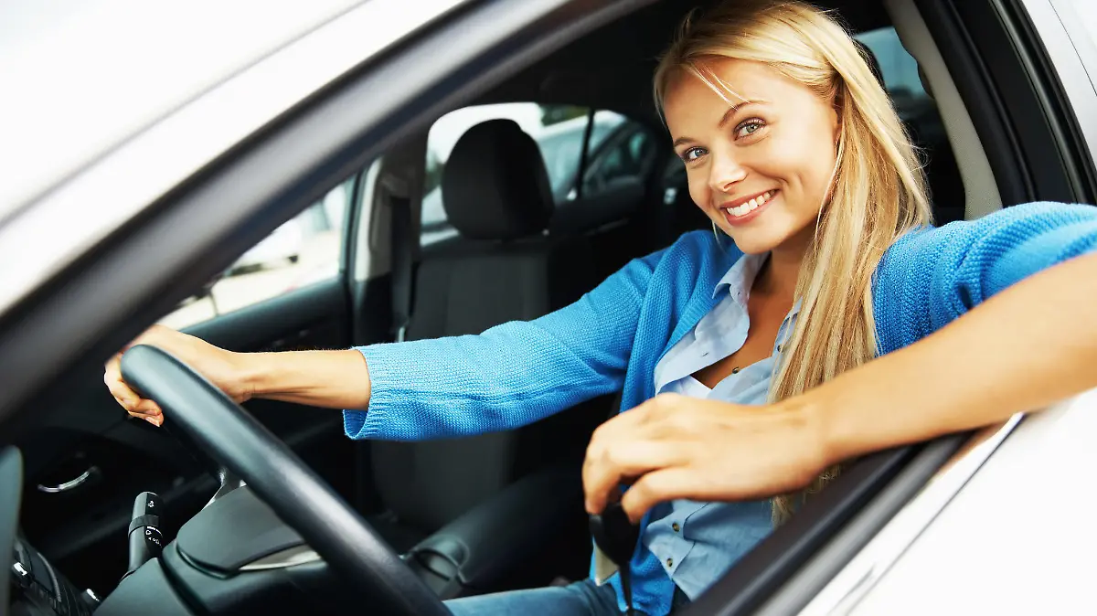Portrait of a young woman sitting in a car and looking out through the window