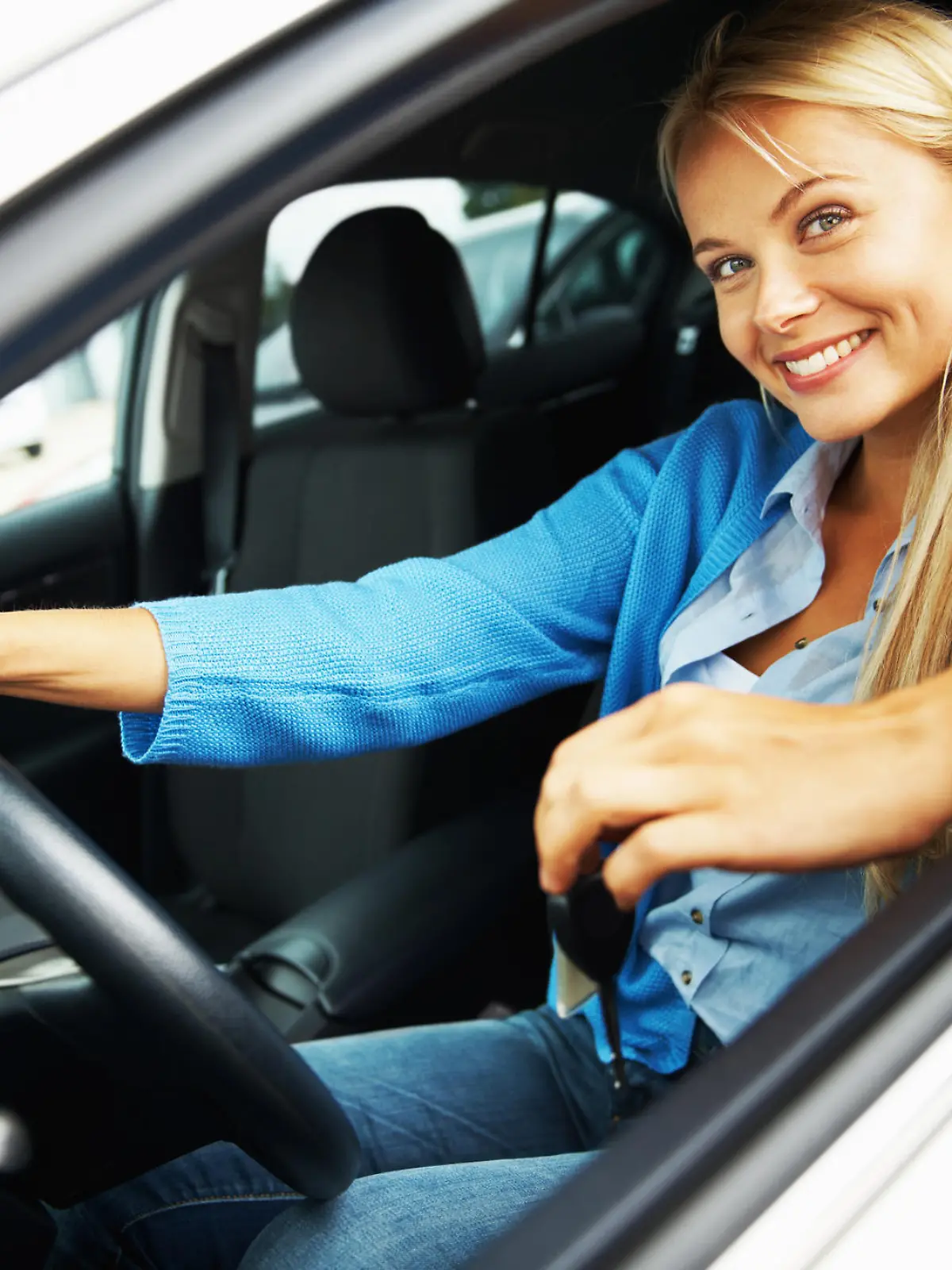 Portrait of a young woman sitting in a car and looking out through the window