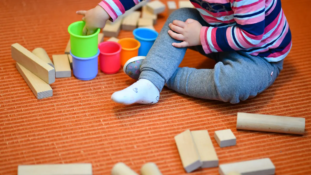 ARCHIV - 20.10.2017, Rheinland-Pfalz, Mannheim: Ein Mädchen spielt in einer Kita mit bunten Bechern und Bauklötzen. (Zu dpa «Kita-Fachkräfteverband stellt Umfrage zu neuem Gesetz vor») Foto: Uwe Anspach/dpa +++ dpa-Bildfunk +++