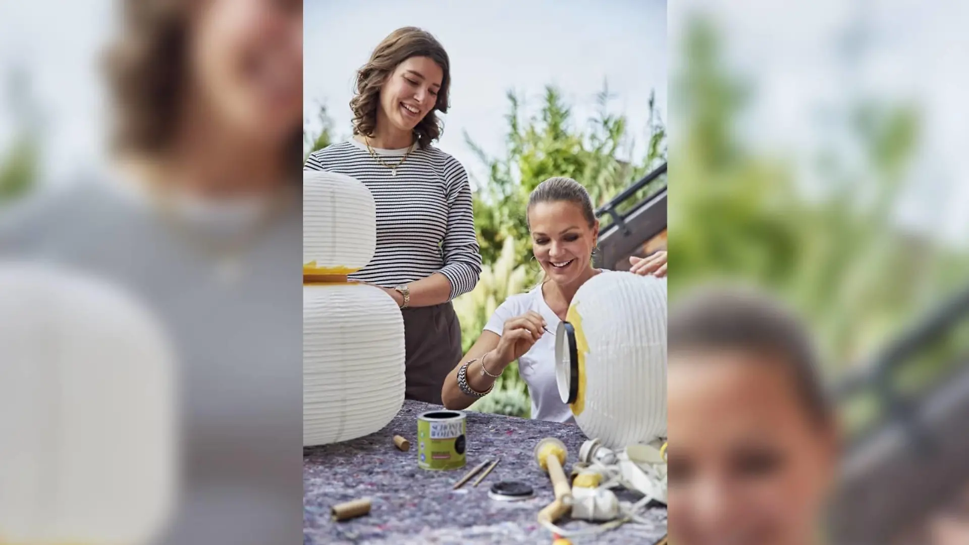 Interior-Expertin Eva Brenner und COUCH-Gewinnerin Katharina malen Lampen für das Wohnzimmer-Umstyling an.
