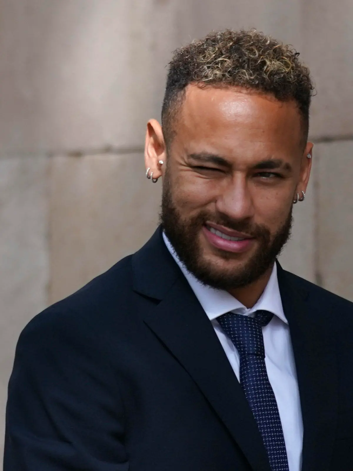 Former FC Barcelona player Neymar who now plays for Paris Saint-Germain winks as he leaves a court on the second day of a trial in Barcelona, Spain, Tuesday Oct. 18, 2022. Neymar appeared in court to face a trial over alleged irregularities involving his transfer to Barcelona in 2013. Neymar's parents, former Barcelona president Sandro Rosell and representatives for both the Spanish club and Brazilian team Santos are also in court after a complaint brought by Brazilian investment group DIS regarding the amount of the player's transfer. (AP Photo/Joan Mateu Parra)