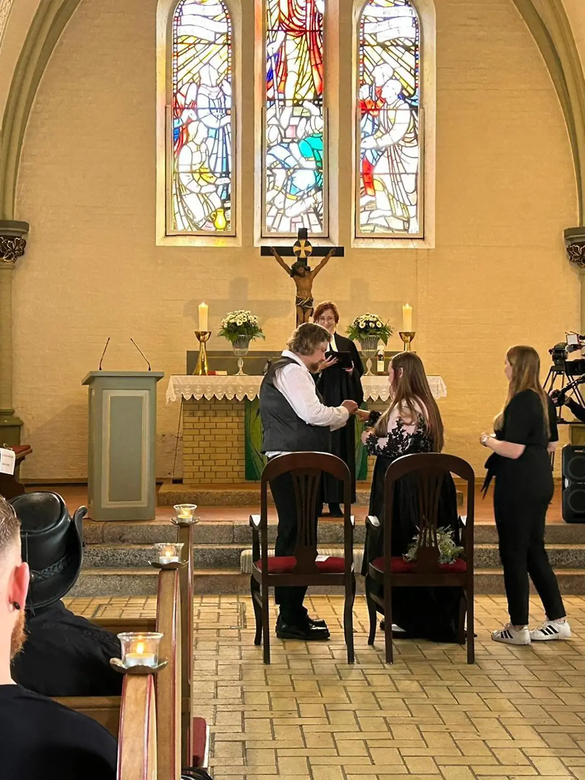 Ein Paar steckt sich vor dem Altar die Eheringe an.