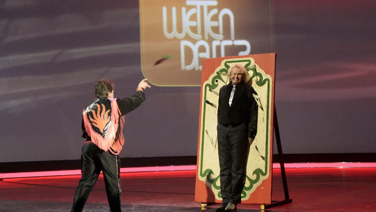 ARCHIV - 13.12.2008, Baden-Württemberg, Stuttgart: Der Moderator Thomas Gottschalk (l) wird in der ZDF-Show «Wetten, dass..?» nach verlorener Saalwette von einem Messerwerfer mit Messern beworfen. (zu dpa-Wiederholung: «Ein letztes Mal mit «Mr. Wetten, dass..?») Foto: Johannes Simon/dpa +++ dpa-Bildfunk +++