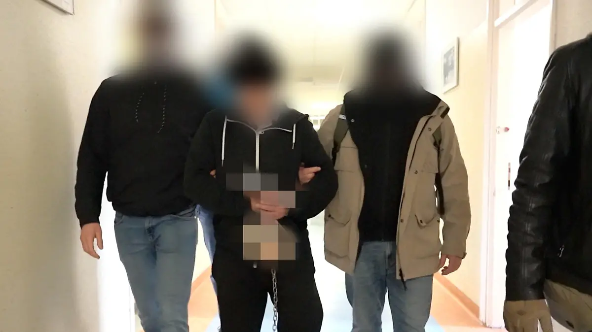 HANDOUT - 24.11.2023, Polen, Warschau: Polizisten bringen den mutmaßlichen Doppel-Mörder (M) zur Vernehmung bei der Bezirksstaatsanwaltschaft Warschau. Mehr als elf Jahre nach dem gewaltsamen Tod eines Hamburger Camper-Ehepaars in Warschau haben polnische Ermittler einen Tatverdächtigen festgenommen. Der 67-Jährige sitze in Untersuchungshaft, sagte der Sprecher der Warschauer Bezirksanwaltschaft, Banna, am Freitag der Deutschen Presse-Agentur.(zu dpa «In Polen erschossenes Ehepaar aus Hamburg: Verdächtiger festgenommen») Foto: Warschauer Polizeikommandantur/Warschauer Bezirksanwaltschaft/dpa - ACHTUNG: Nur zur redaktionellen Verwendung im Zusammenhang mit einer Berichterstattung über den Prozess und nur mit vollständiger Nennung des vorstehenden Credits. ACHTUNG: Person(en) wurde(n) aus rechtlichen Gründen gepixelt +++ dpa-Bildfunk +++