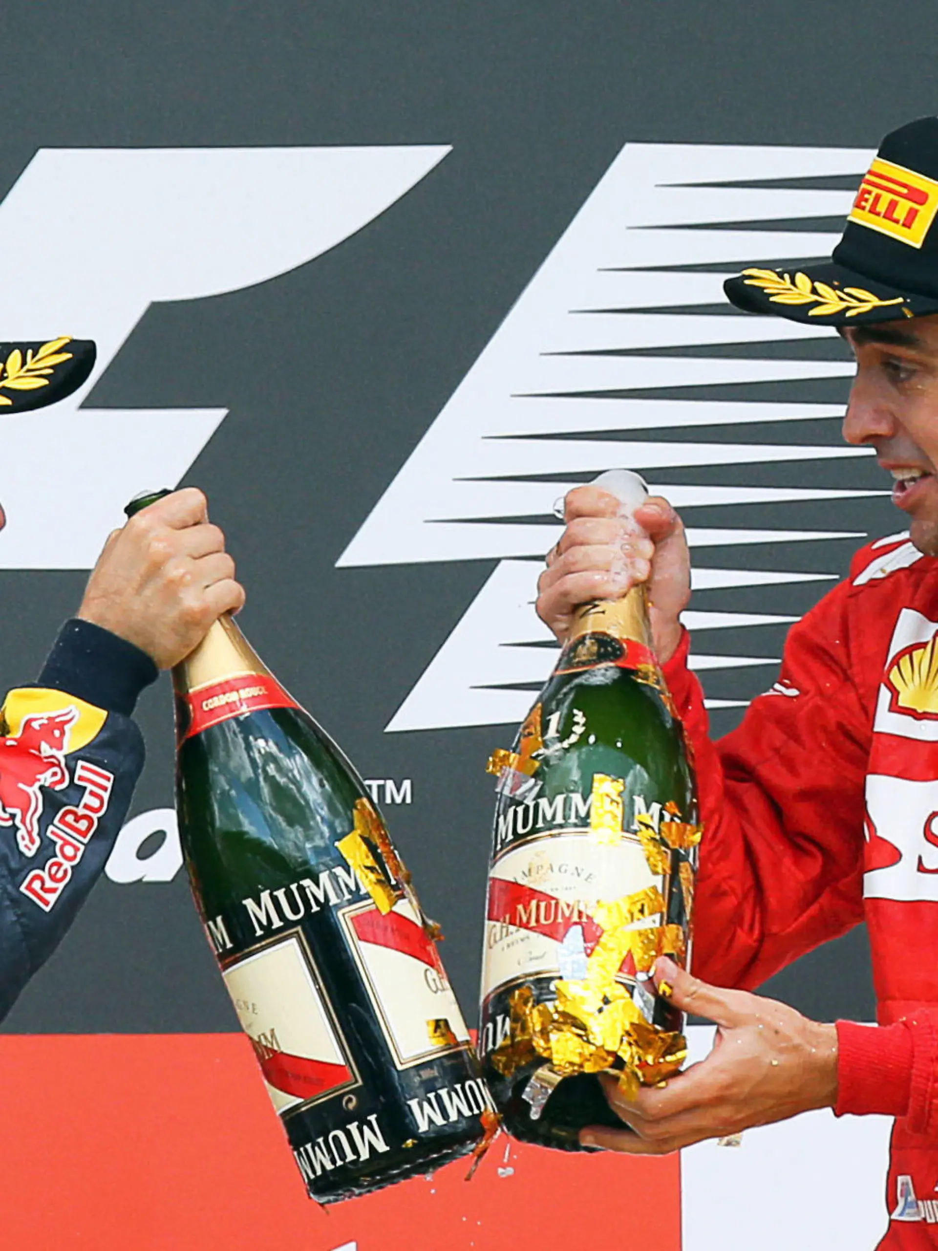 ARCHIV - Der deutsche Formel-1-Pilot Sebastian Vettel von Red Bull und sein spanischer Kontrahent Fernando Alonso von Ferrari prosten sich nach dem Großen Preis von Deutschland am 22.07.2012 in Hockenheim auf dem Podium mit Champagnerflaschen zu. Am Sonntag (07.10.2012) geht es für die beiden beim Großen Preis von Japan um entscheidende WM-Punkte. Foto: Jens Buettner/dpa (zu dpa KORR: «Japan-Rennen Auftakt zu Wochen der Formel-1-Entscheidungen » vom 03.10.2012)  +++(c) dpa - Bildfunk+++