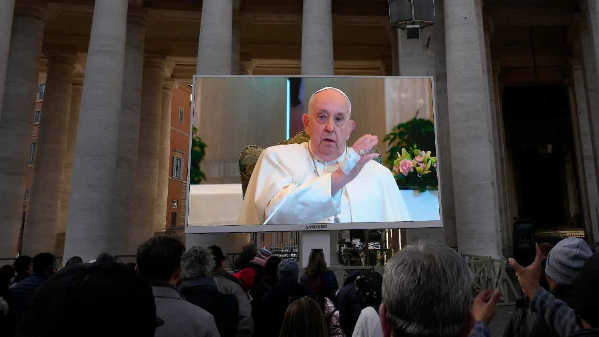 26.11.2023, Vatikan, Vatikanstadt: Papst Franziskus ist auf einem  Monitor auf dem Petersplatz zu sehen, um die Gläubigen zu segnen, die sich zum traditionellen Angelus-Mittagsgebet auf dem Platz versammelt haben. PPapst Franziskus hat wegen einer Erkrankung Termine absagen lassen. Foto: Alessandra Tarantino/AP/dpa +++ dpa-Bildfunk +++