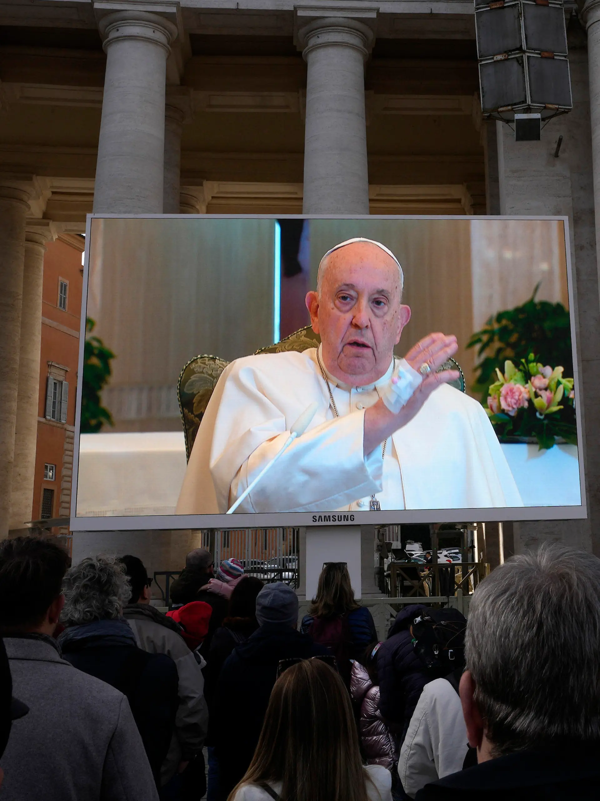 26.11.2023, Vatikan, Vatikanstadt: Papst Franziskus ist auf einem  Monitor auf dem Petersplatz zu sehen, um die Gläubigen zu segnen, die sich zum traditionellen Angelus-Mittagsgebet auf dem Platz versammelt haben. PPapst Franziskus hat wegen einer Erkrankung Termine absagen lassen. Foto: Alessandra Tarantino/AP/dpa +++ dpa-Bildfunk +++