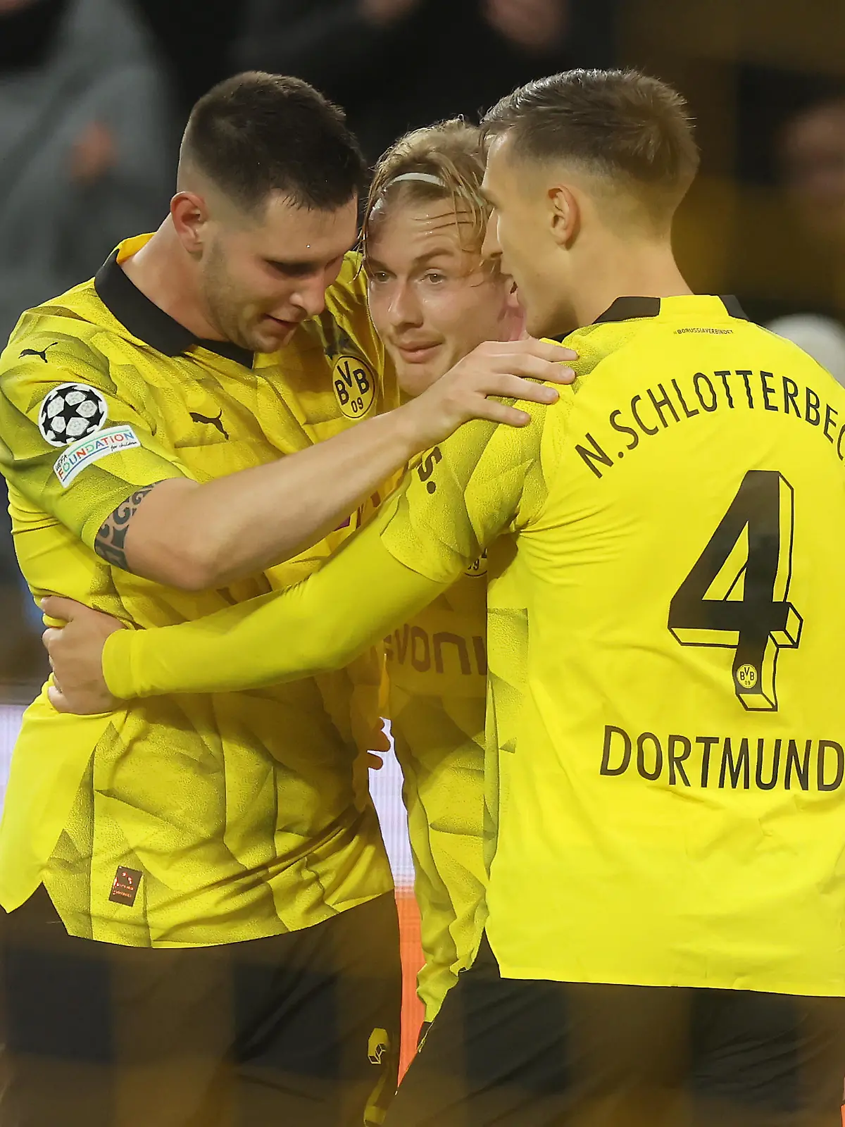 DORTMUND, GERMANY - NOVEMBER 07: Julian Brandt of Borussia Dortmund (C) celebrates with teammates Niklas Suele (L) and Nico Schlotterbeck after scoring the team's second goal during the UEFA Champions League match between Borussia Dortmund and Newcastle United at Signal Iduna Park on November 07, 2023 in Dortmund, Germany. (Photo by Alex Grimm/Getty Images)