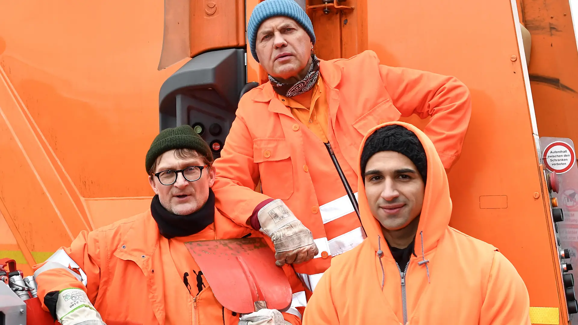 EXKLUSIV: 12.02.2018, Berlin: Die Schauspieler Jörn Hentschel als Ralle (l-r), Uwe Ochsenknecht als Werner und Daniel Rodic als Tarik stehen am Rande von Dreharbeiten der ARD-Degeto-Komödie "Die Drei von der Müllabfuhr" über den Alltag dreier Berliner Müllmänner an einem Müllfahrzeug. Foto: Jens Kalaene/dpa-Zentralbild/dpa