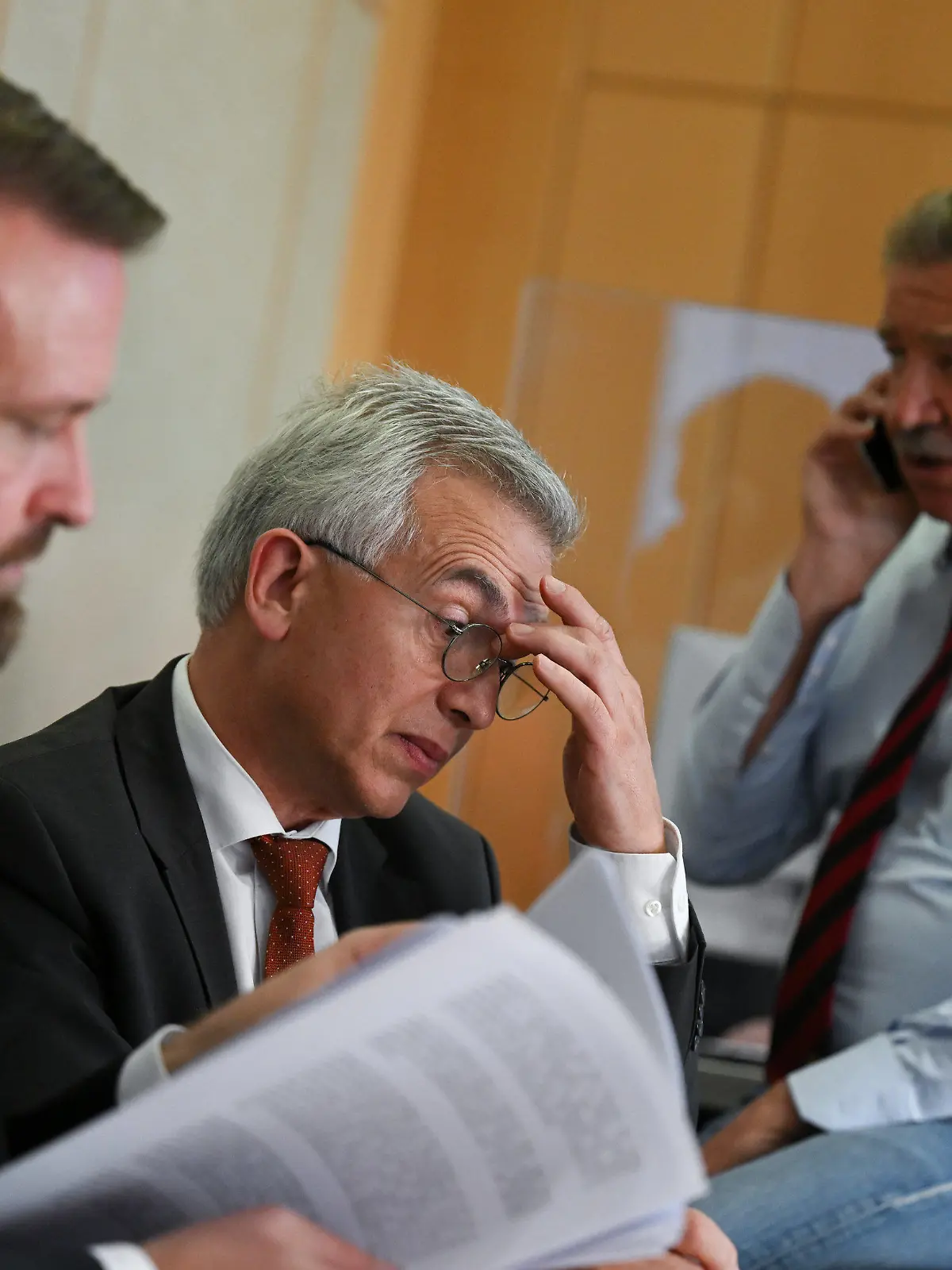 27.10.2022, Hessen, Frankfurt/Main: Peter Feldmann (SPD, M), Oberbürgermeister von Frankfurt am Main, schaut während einer Pause des zweiten Prozesstages im Gerichtssaal des Landgerichts zwischen seinen Anwälten David Hofferbert (l) und Ulrich Endres auf seinen Tablet-Computer. Der umstrittene Oberbürgermeister muss sich vor dem Landgericht wegen Korruptionsvorwürfen verantworten. Foto: Arne Dedert/dpa/POOL/dpa +++ dpa-Bildfunk +++