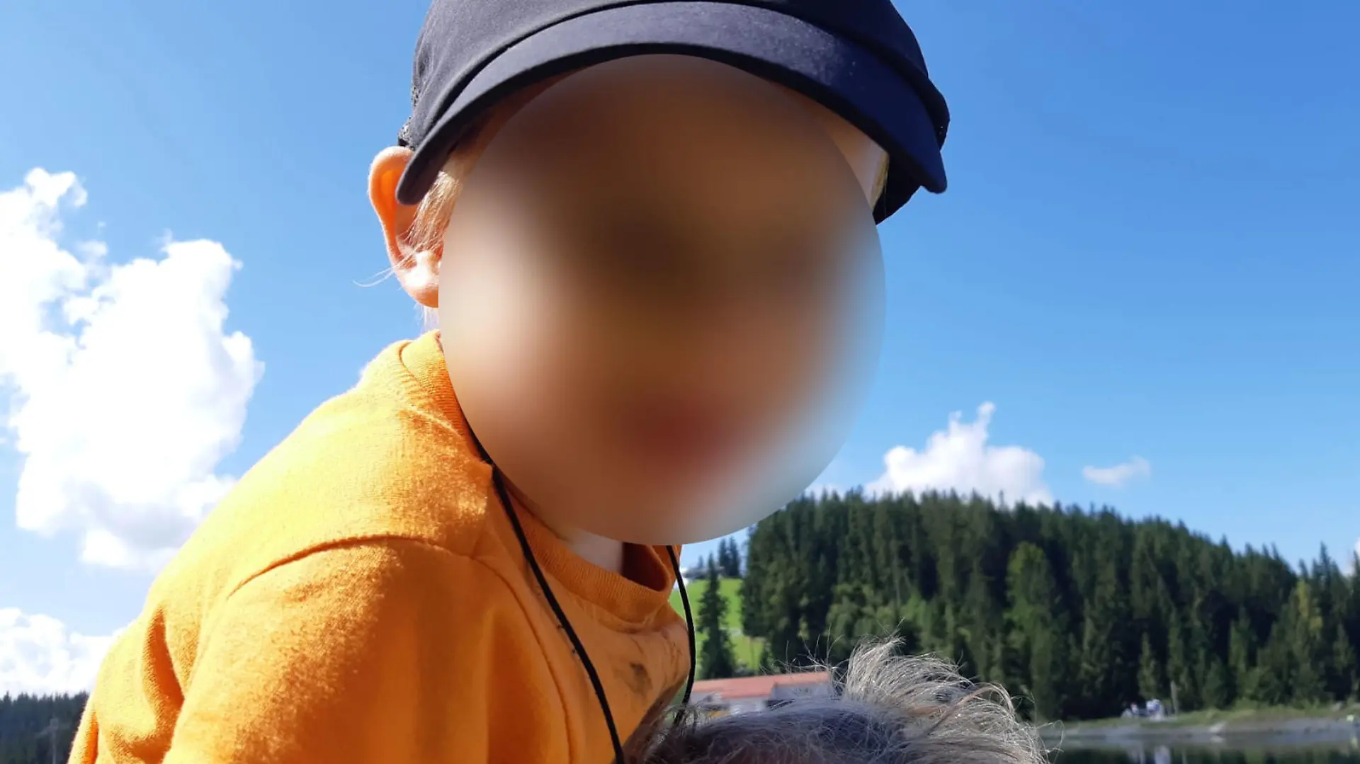 Kleiner Junge in orangenem T-Shirt