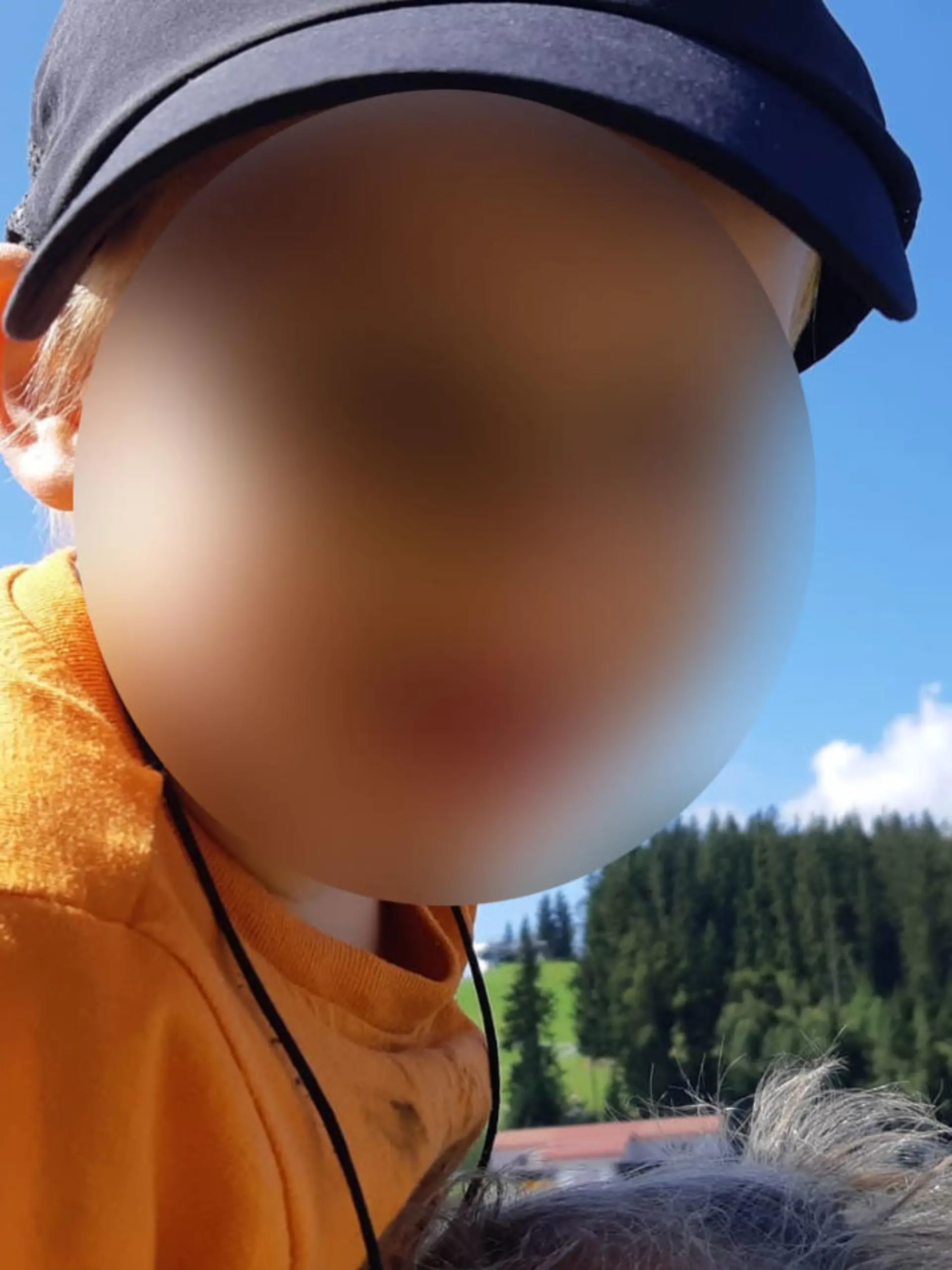 Kleiner Junge in orangenem T-Shirt