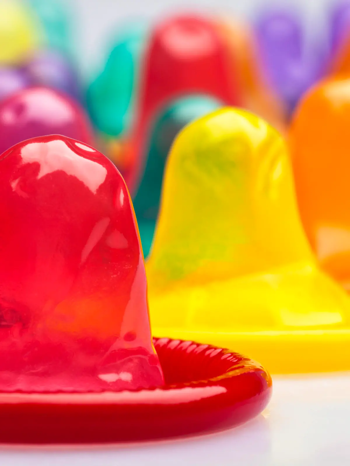 Extreme close-up of condoms in a rainbow of colors.