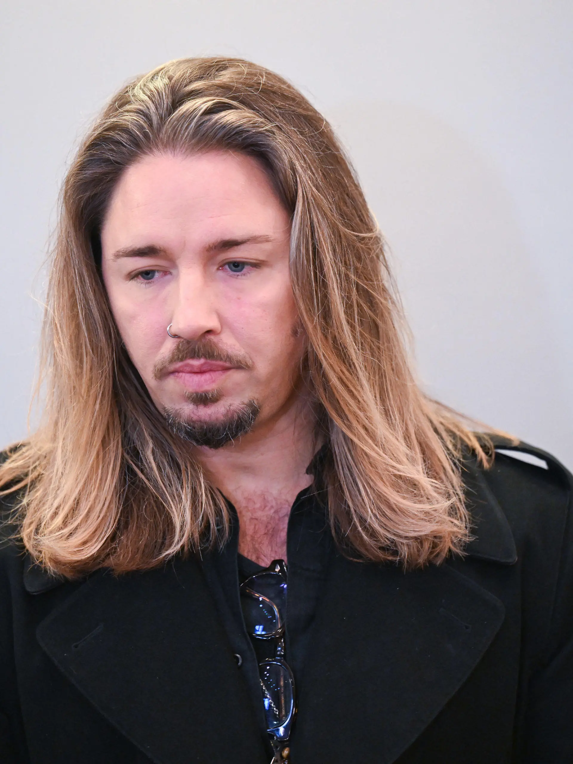 28.11.2023, Sachsen, Leipzig: Der deutsche Rockmusiker Gil Ofarim steht im Saal des Landgerichts in Leipzig. Hier läuft der Prozess gegen Ofarim wegen falscher Verdächtigung und Verleumdung. Der Musiker hatte im Oktober 2021 in einem Video Antisemitismus-Vorwürfe gegen ein Leipziger Hotel erhoben. Nach Einschätzung der Staatsanwaltschaft Leipzig hat sich der Vorfall aber nicht so zugetragen. Foto: Hendrik Schmidt/dpa +++ dpa-Bildfunk +++