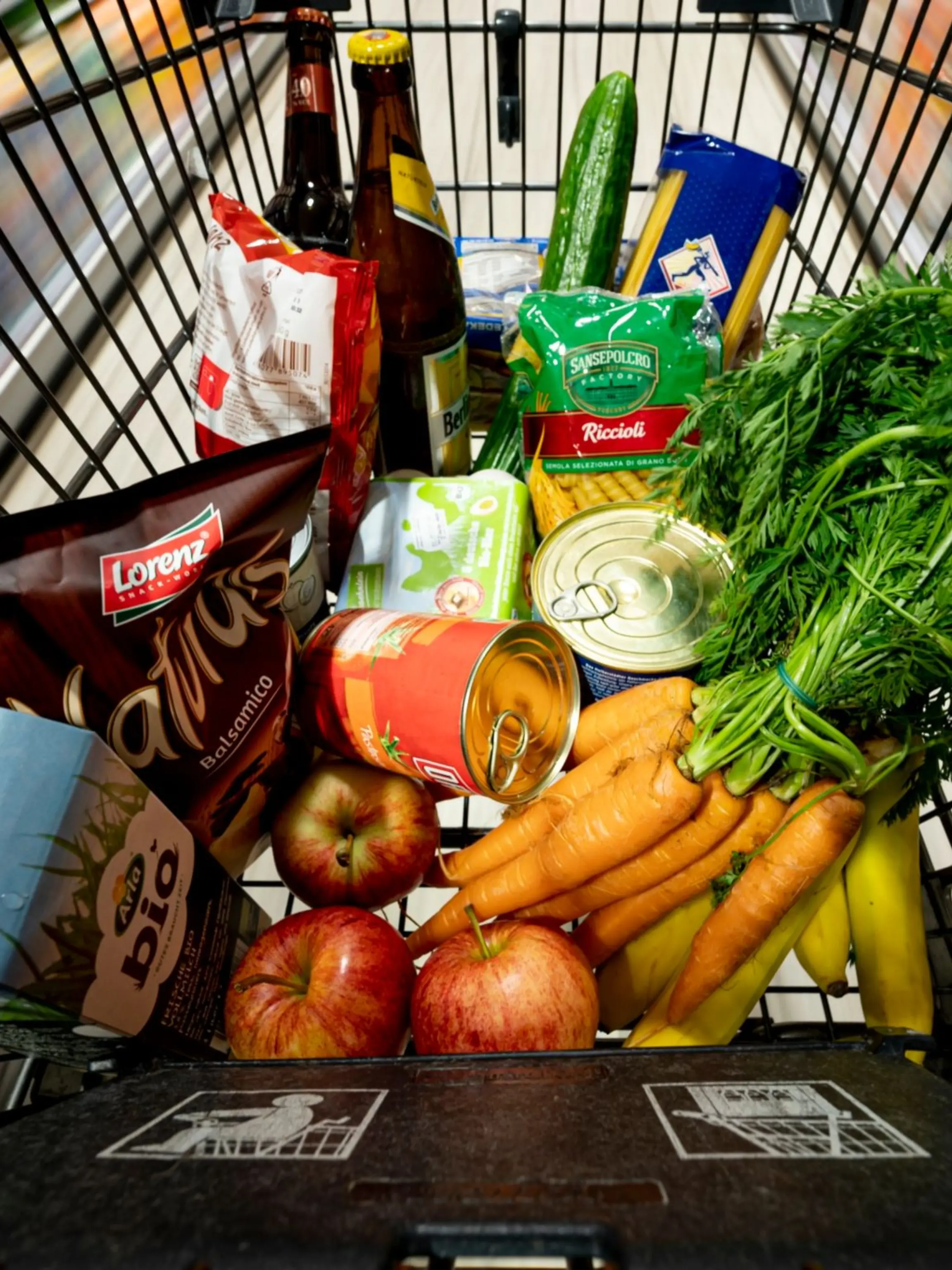 Lebensmittel liegen in einem Einkaufswagen in einem Supermarkt.