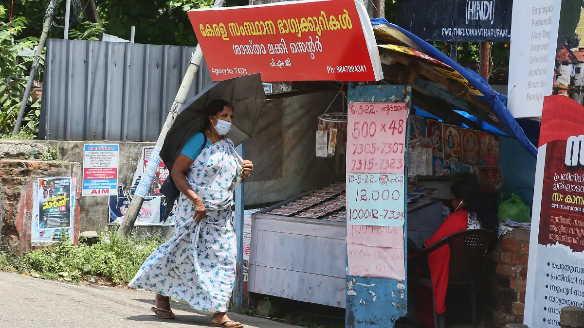 Woman walks past a small stand selling lottery tickets along the roadside in the city of Thiruvananthapuram (Trivandrum), Kerala, India on May 12, 2022. (Photo by Creative Touch Imaging Ltd./NurPhoto)