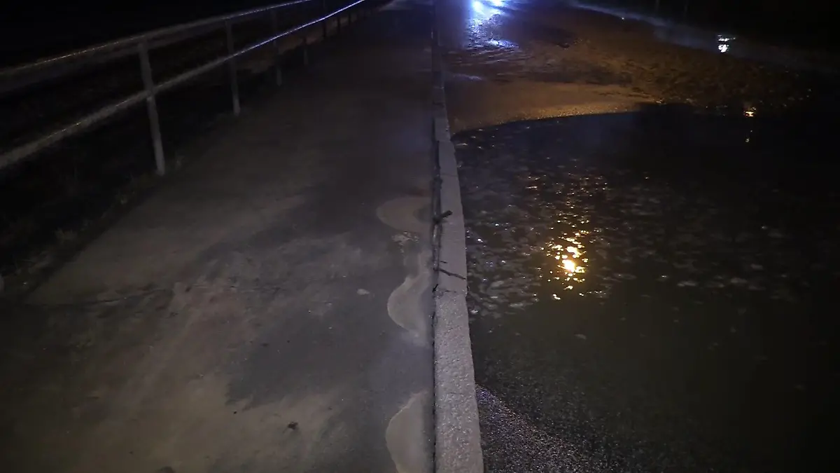 Das Wasser sammelt sich in der Nacht auf der Straße.