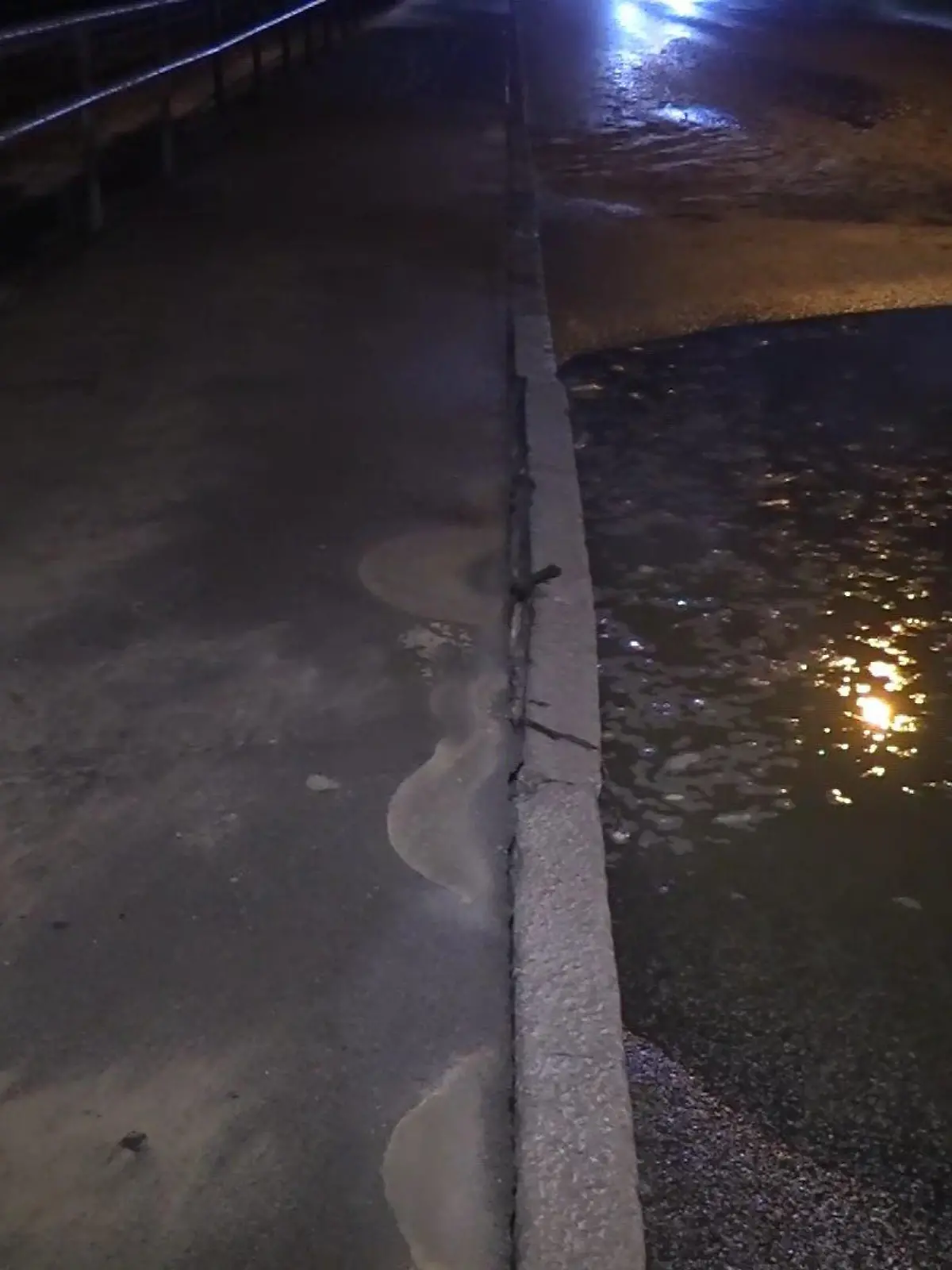 Das Wasser sammelt sich in der Nacht auf der Straße.