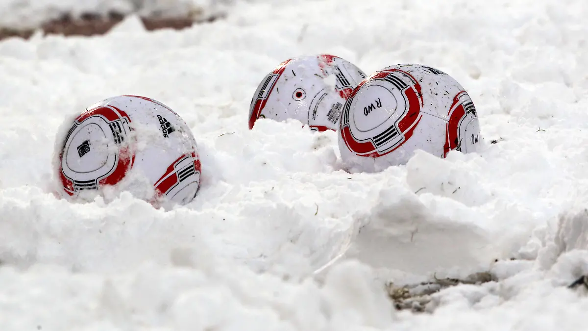 ARCHIV - Fußbälle liegen am 19.12.2010 bei der Zweitligabegegnung SC Rot-Weiß Oberhausen - FC Energie Cottbus im Oberhausener Niederrhein-Stadion im Schnee. Eis und Schnee haben den Fans die Lust auf Fußball im Winter gründlich verdorben. Mehr als die Hälfte der Fußball- Anhänger ist für eine Umstellung der Saison auf das Kalenderjahr mit Start im März und Meister-Kür im November. Foto: Roland Weihrauch dpa (zu dpa-Umfrage: "Wintermüde Fußball-Fans für anderen Spielplan" vom 23.12.2010) +++(c) dpa - Bildfunk+++