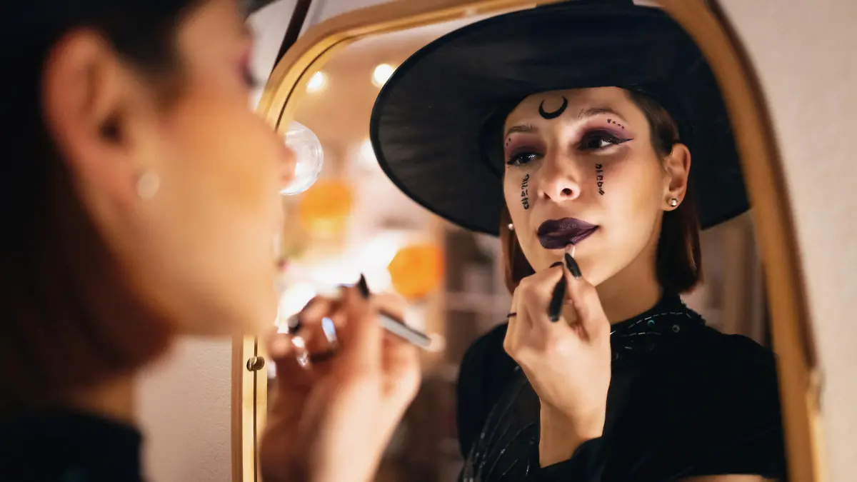 Young Caucasian woman doing make-up for Halloween party.