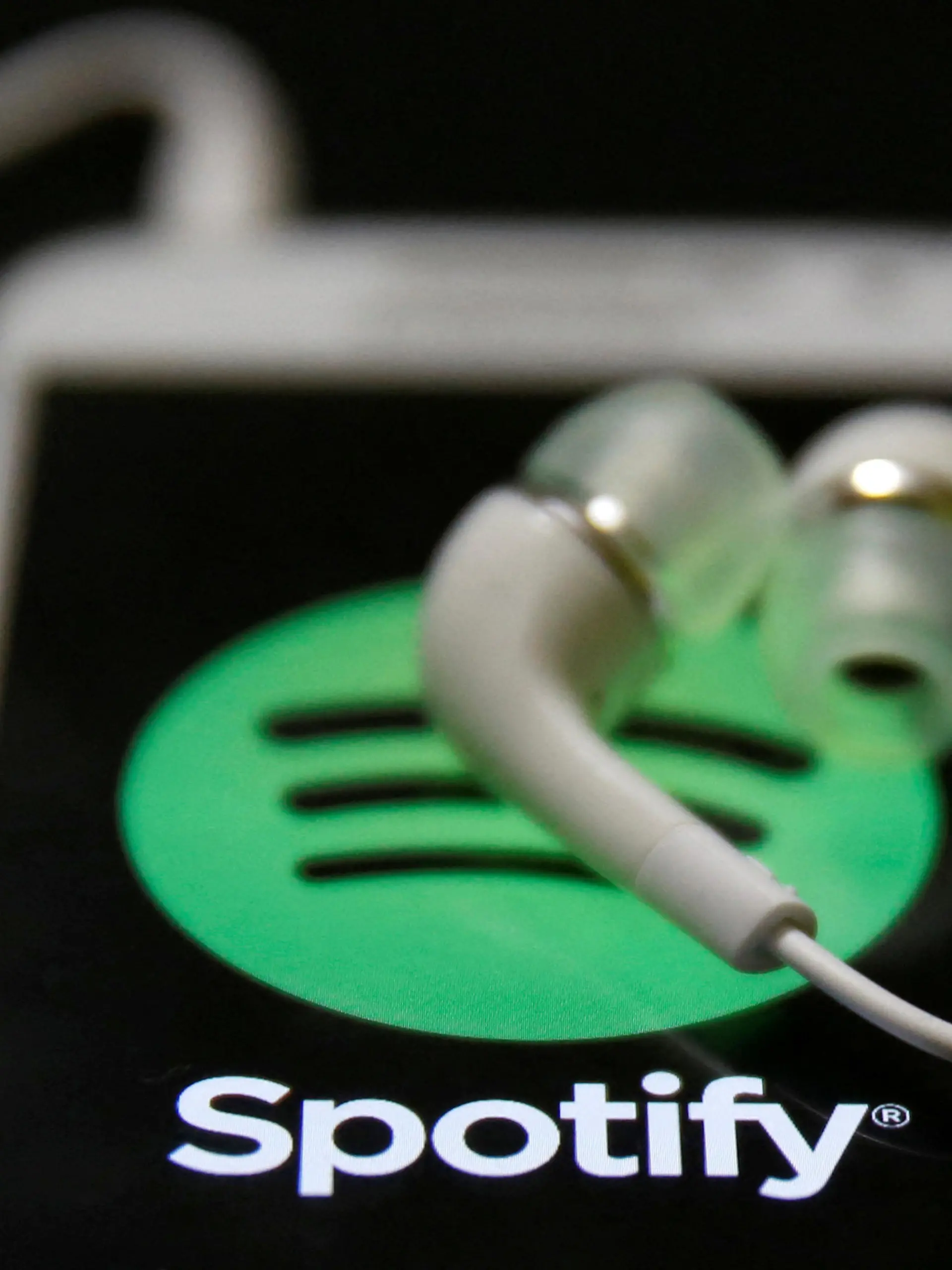 FILE PHOTO: Earphones are seen on top of a smart phone with a Spotify logo on it, in Zenica February 20, 2014. REUTERS/Dado Ruvic/File Photo