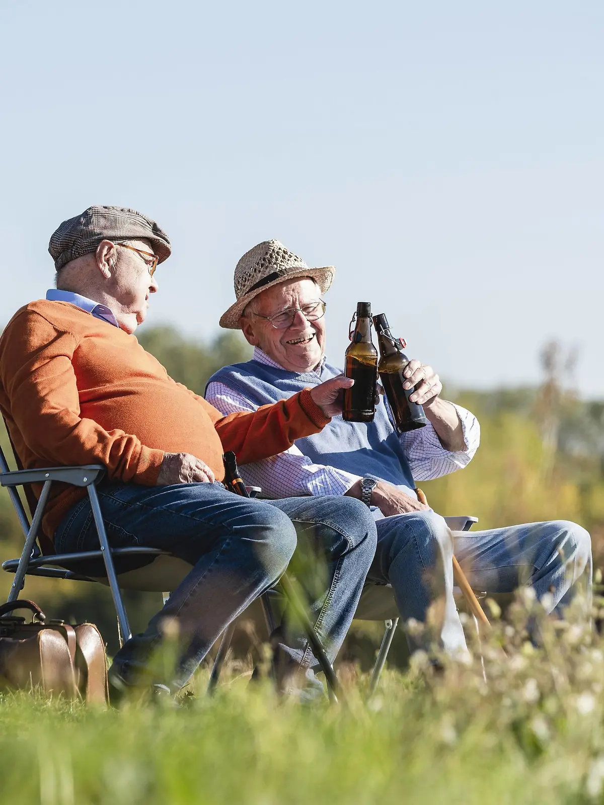 Two old friends sitting in the fields, drinking beer, talking about old times model released Symbolfoto PUBLICATIONxINxGERxSUIxAUTxHUNxONLY UUF15478  