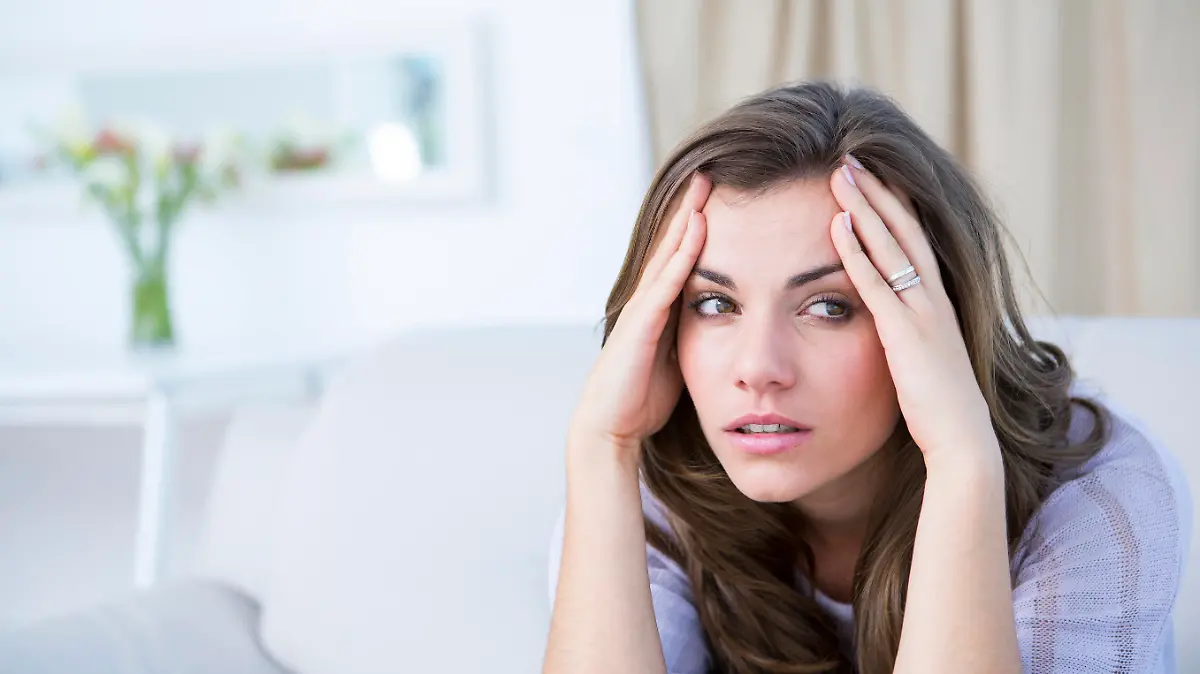Sick woman suffering from head ache at home in the living room 