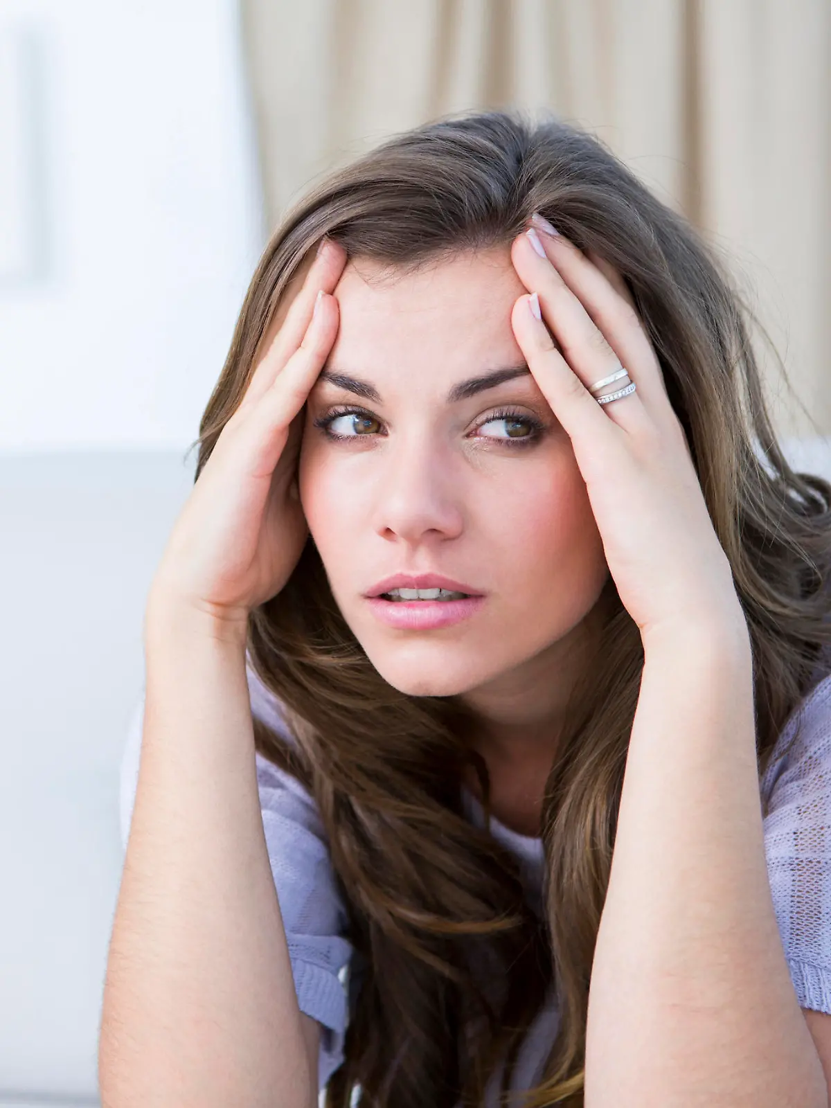 Sick woman suffering from head ache at home in the living room 