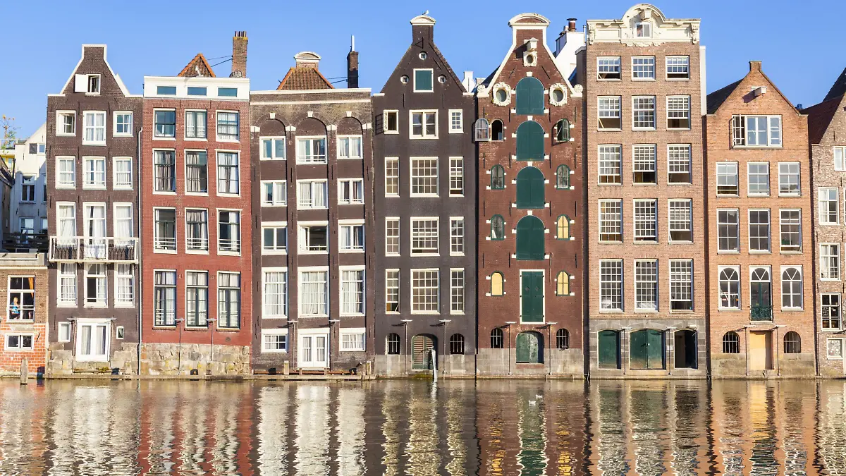 Dutch gables on a row of typical Amsterdam houses with reflections, Damrak Canal, Amsterdam, North Holland, Netherlands, Europe PUBLICATIONxINxGERxSUIxAUTxONLY Copyright: NealexClark 698-3369