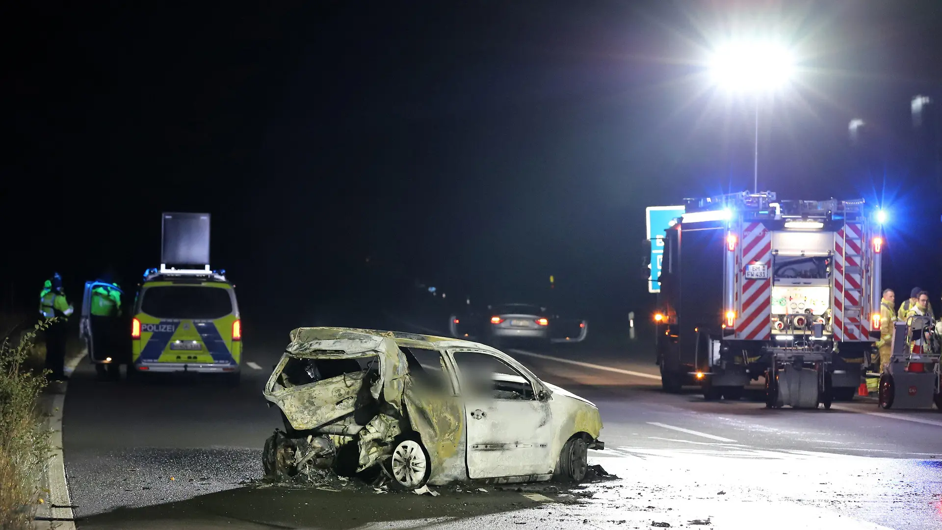 02.12.2023, Nordrhein-Westfalen, Wesseling: Ein verunfalltes Auto steht auf der Autobahn 555 zwischen Köln und Bonn. Zwei Menschen sind bei dem Unfall gestorben. Nach ersten Informationen der Polizei sollen mindestens zwei Fahrzeuge beteiligt gewesen sein. Ein Auto geriet durch den Unfall am Freitagabend in Brand. Rettungskräfte konnten nur noch die Leichen der beiden Insassen bergen. Mindestens zwei weitere Menschen seien leicht verletzt worden und kamen in Krankenhäuser. Foto: Sascha Thelen/dpa - ACHTUNG: Person(en) wurde(n) aus rechtlichen Gründen gepixelt +++ dpa-Bildfunk +++