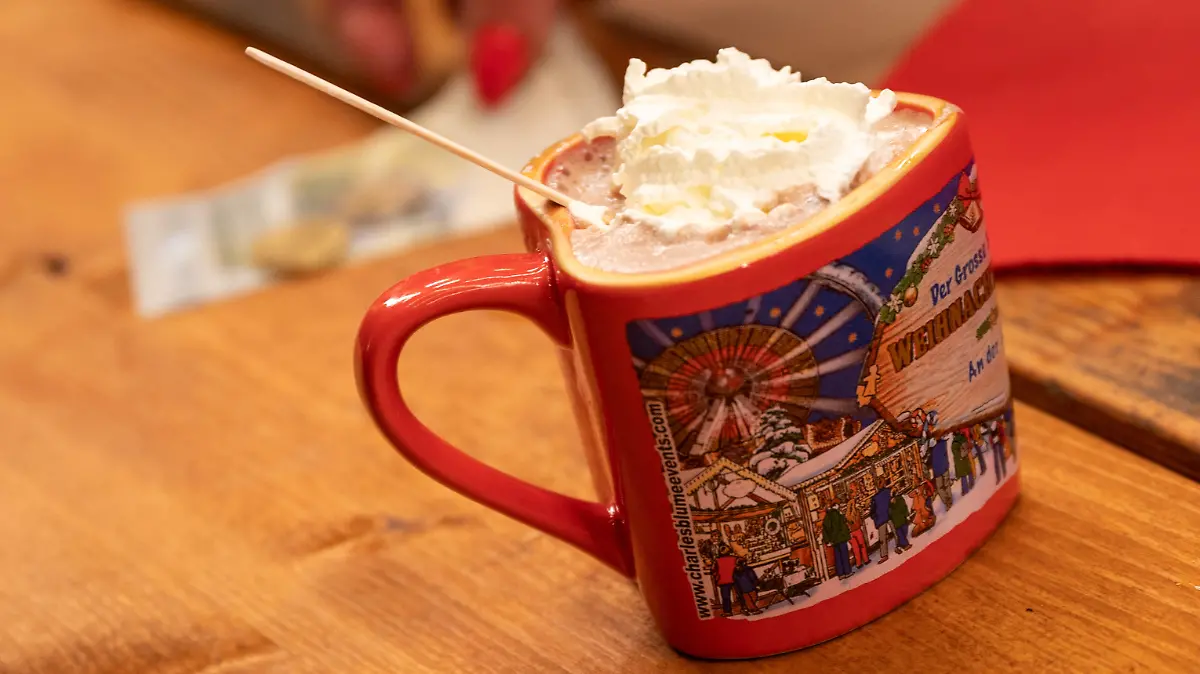 Eine Tasse heiße Schokolade mit Sahne steht an einem Stand auf dem Weihnachtsrummel „Winterzauber Berlin“. Ungeachtet steigender Corona-Infektionszahlen ist in Berlin die Weihnachtsmarkt-Saison gestartet.