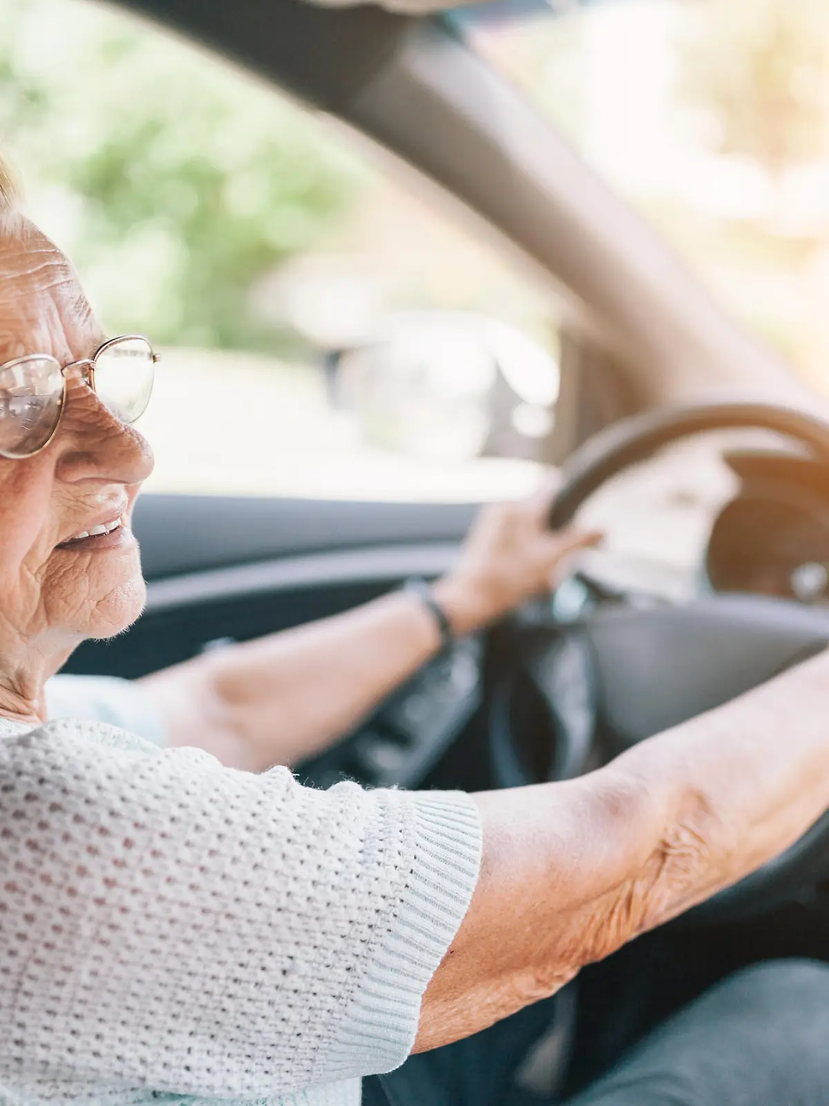 Elderly woman behind the steering wheel of a car