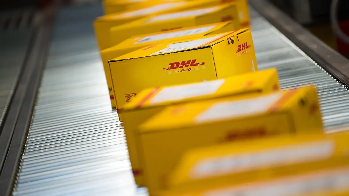 Pakete liegen auf einem Förderband an einem DHL Express Logistikstandort.