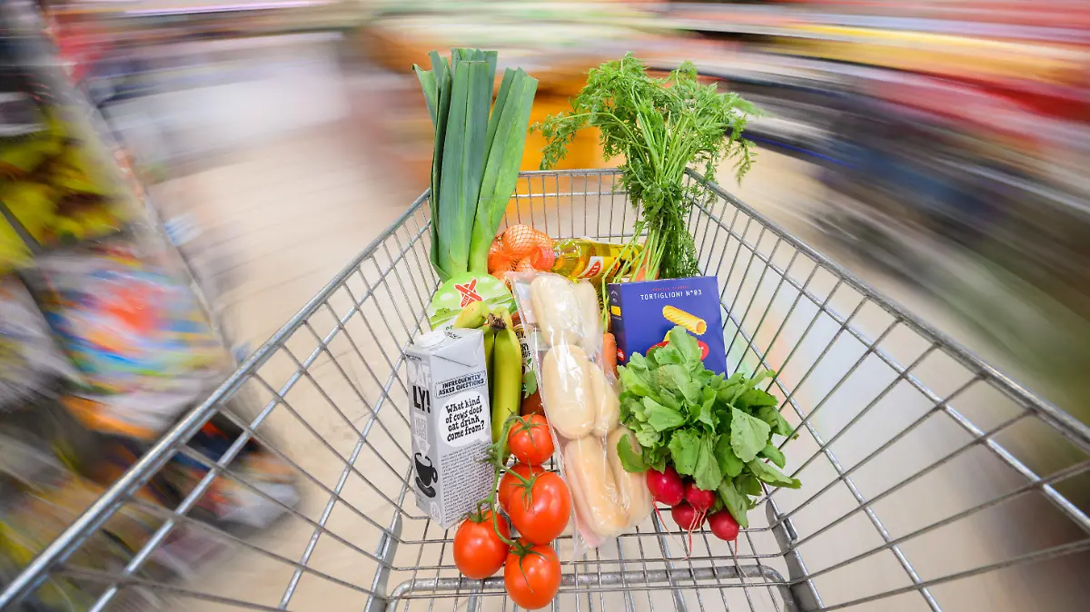 ARCHIV - 30.08.2023, Niedersachsen, Hannover: ILLUSTRATION - Ein mit Lebensmittel gefüllter Einkaufswagen wird durch einen Supermarkt geschoben (gestellte Szene, Aufnahme mit langer Verschlusszeit). Seit Ausbruch des Ukraine-Krieges am 24. Februar 2022 treibt die zeitweise zweistellige Inflation Deutschlands Verbrauchern erneut Sorgenfalten auf die Stirn. (zu dpa: «Hartnäckig, aber anders als 1923: Inflation auf dem Rückzug») Foto: Julian Stratenschulte/dpa +++ dpa-Bildfunk +++