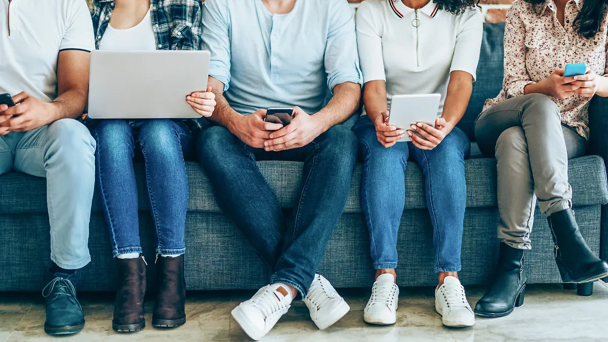 Jugendliche sitzen an Tablets und Smartphones