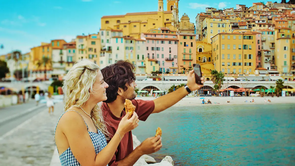 Pärchen, das ein Selfie macht und auf eine Altstadt blickt.