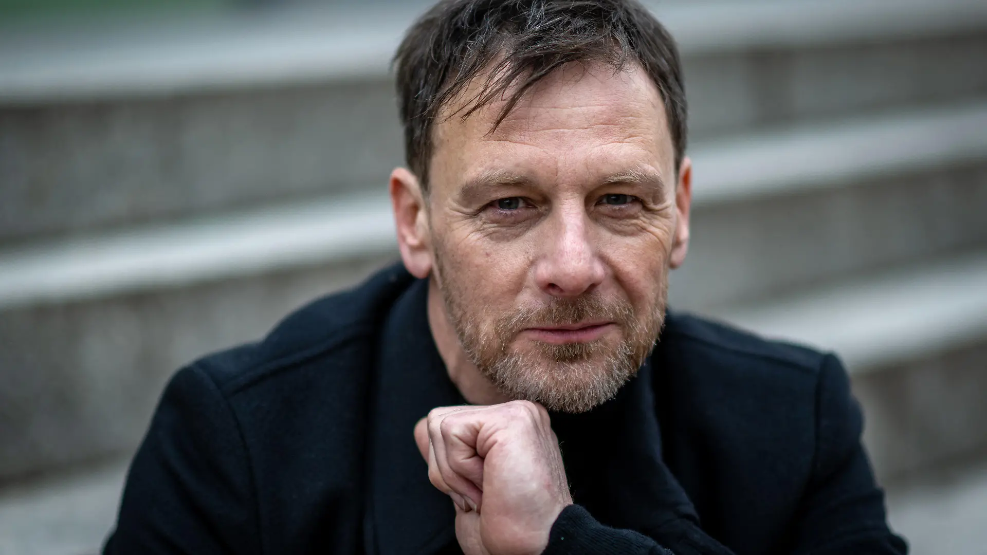 PRODUKTION - 10.01.2023, Sachsen, Leipzig: Hendrik Duryn, Schauspieler, lächelt bei einem Fototermin. Er spielt den eigenwilligen Tjark Wolf, einen Mordermittler in «Dünentod - Ein Nordsee-Krimi», der am 31.01.2023 auf RTL ausgestrahlt wird. (zu dpa "Schauspieler Hendrik Duryn: Im Zentrum steht die Idee des Films") Foto: Hendrik Schmidt/dpa +++ dpa-Bildfunk +++