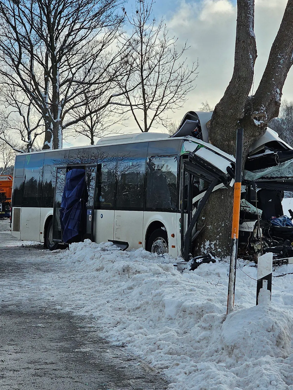 05.12.2023, Sachsen, Sehmatal-Cranzahl: Einsatzkräfte stehen an der Unfallstelle. Bei einem Unfall mit einem Schulbus in Sehmatal im Erzgebirge ist am Dienstagmorgen ein Kind getötet worden. Mindestens zehn weitere Schulkinder wurden verletzt. Zudem wurden zwei Erwachsene - darunter der Busfahrer - schwer verletzt. (Zu dpa: «Kind bei Schulbusunfall im Erzgebirge getötet - viele Verletzte») Foto: Mike Müller/dpa-Zentralbild/dpa +++ dpa-Bildfunk +++