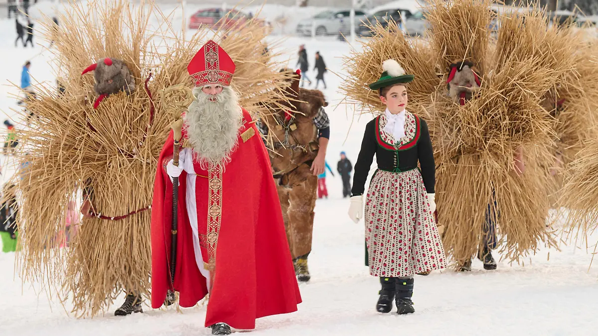 Bischofswiesen, Deutschland 03. Dezember 2023: Buttnmandl in Loipl - 03.12.2023 Im Bild: Alljaehrlich am ersten Advent begleiten in Stroh und Fell gehuellte Buttnmandl und Kramperl den Heiligen Nikolaus von Haus zu Haus beim Buttnmandl Laufen in Loipl bei Bischofswiesen. Die in langes Stroh eingebundenen Buttnmandl und in Fell gekleideten Kramperl tragen nach uralter Tradition furchteinfloeßende Holz- oder Fellmasken, schwere Kuhglocken und eine Rute, die so mancher mit einem Schlag um die Beine zu spüren bekommt. Der Nikolaus trägt die festliche Kleidung eines Bischofs und wird in Bischofswiesen vom Nikoloweibl , einem in Maedchentracht gekleideten Buben begleitet. Man versammelte sich zum Gebet: zwei ÂVater unserÂ, ein ÂGegrueà Copyright: xFotostandx/xWassmuthx