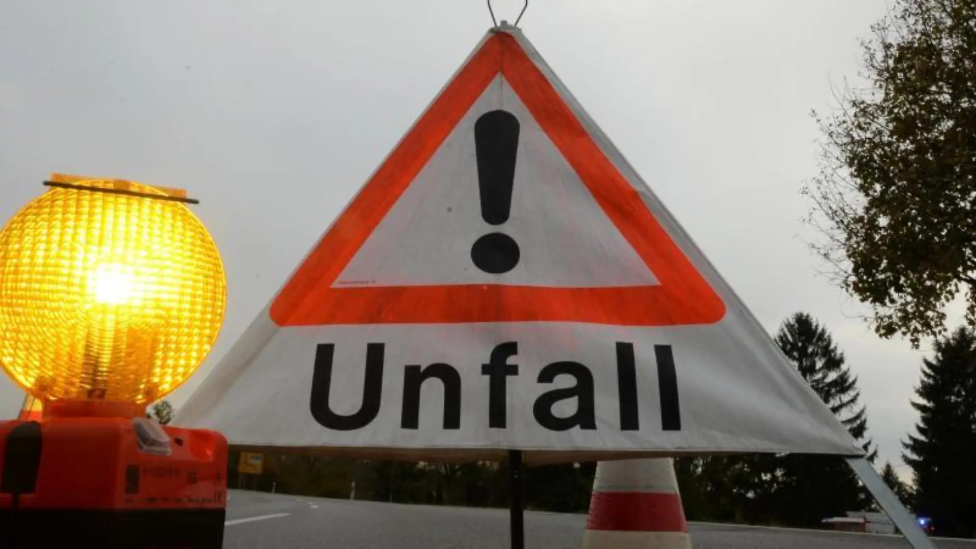Ein Warndreieck mit der Aufschrift «Unfall» steht auf der Straße