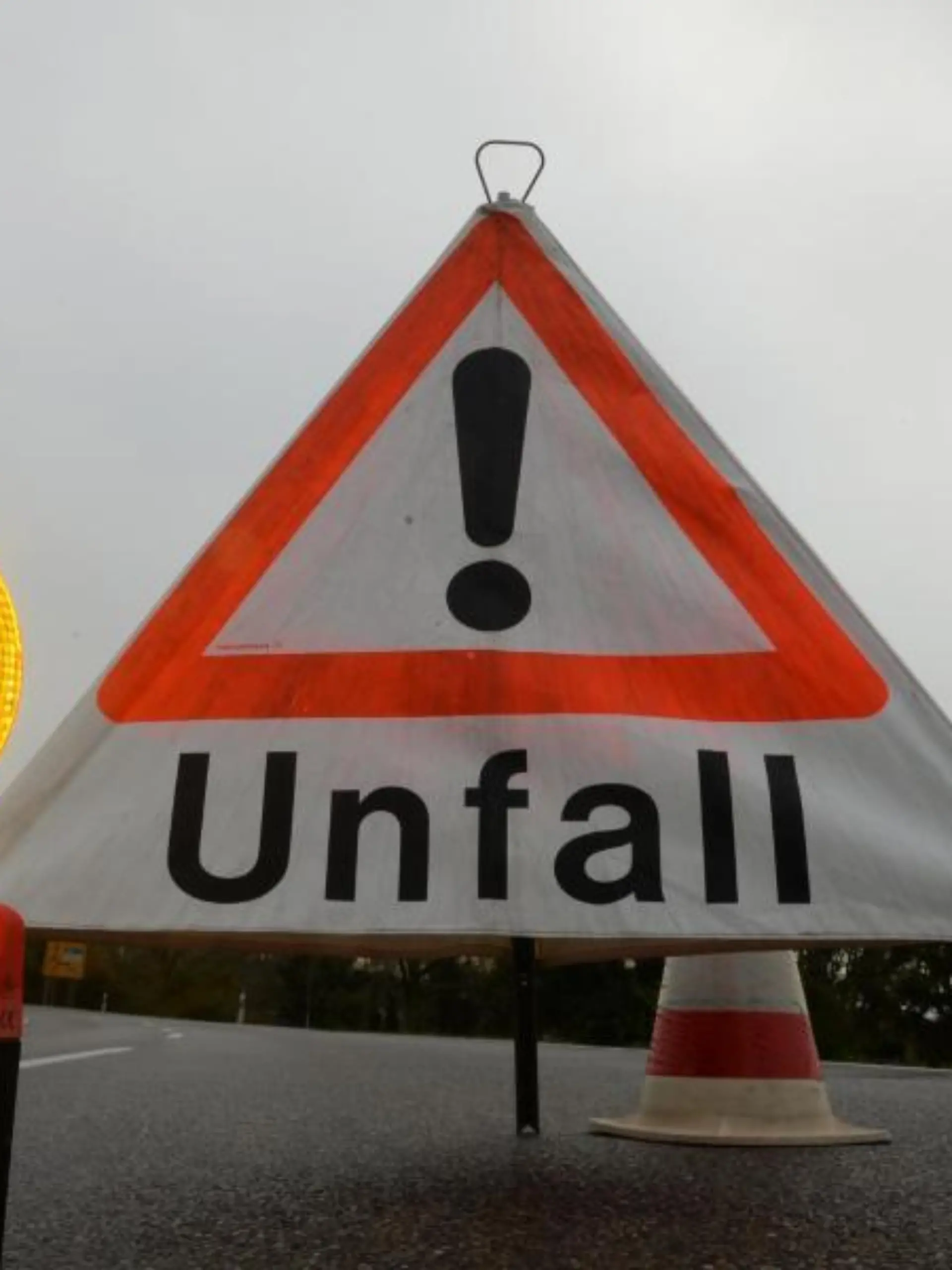 Ein Warndreieck mit der Aufschrift «Unfall» steht auf der Straße
