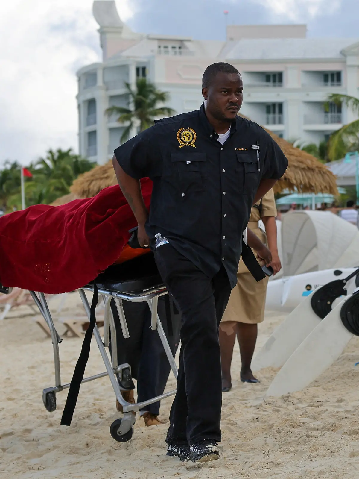 Mortuary services personnel transport the body of a female tourist after what police described as a fatal shark attack in waters near Sandals Royal Bahamian resort, in Nassau, Bahamas December 4, 2023.  REUTERS/Dante Carrer
