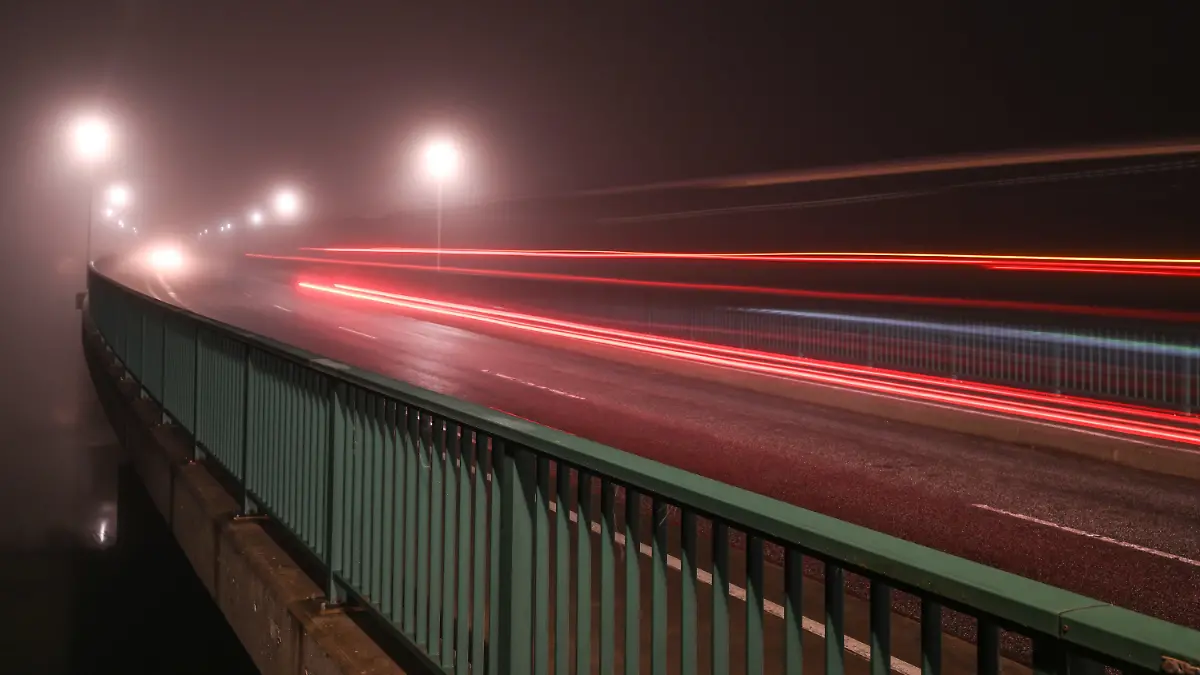 30.11.2023, Niedersachsen, Leer: Die wohl vorerst letzten Autos passieren die Jann-Berghaus-Brücke bei Nebel. Im Tarifstreit des öffentlichen Dienstes der Länder hat Verdi für Donnerstag Straßenwärterinnen und Straßenwärter zu Warnstreiks aufgerufen. Betroffen sind Niedersachsen und Bremen für 24 Stunden. Die Gewerkschaft selbst verwies als Schwerpunkte aber eher auf die Jan-Berghaus-Brücke in Leer und die Huntebrücke bei Oldenburg, die beide während des Warnstreiks hochgeklappt bleiben sollen. Foto: Lars Penning/dpa +++ dpa-Bildfunk +++