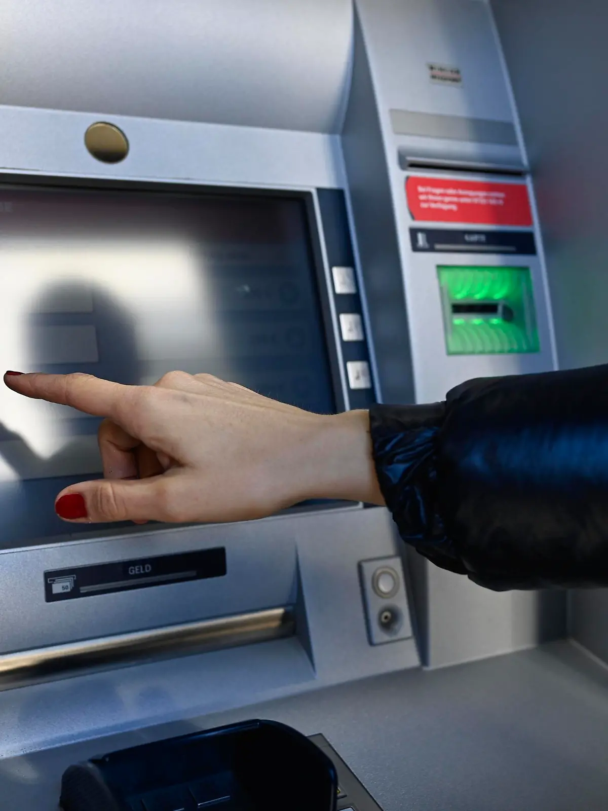 Frau tippt am Touchscreen eines Geldautomaten einer Sparkasse, Waiblingen, Baden-Württemberg, Deutschland, Europa || Modellfreigabe vorhanden